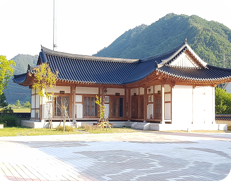 산을 배경으로 자리한 왕산 한옥체험관 외관